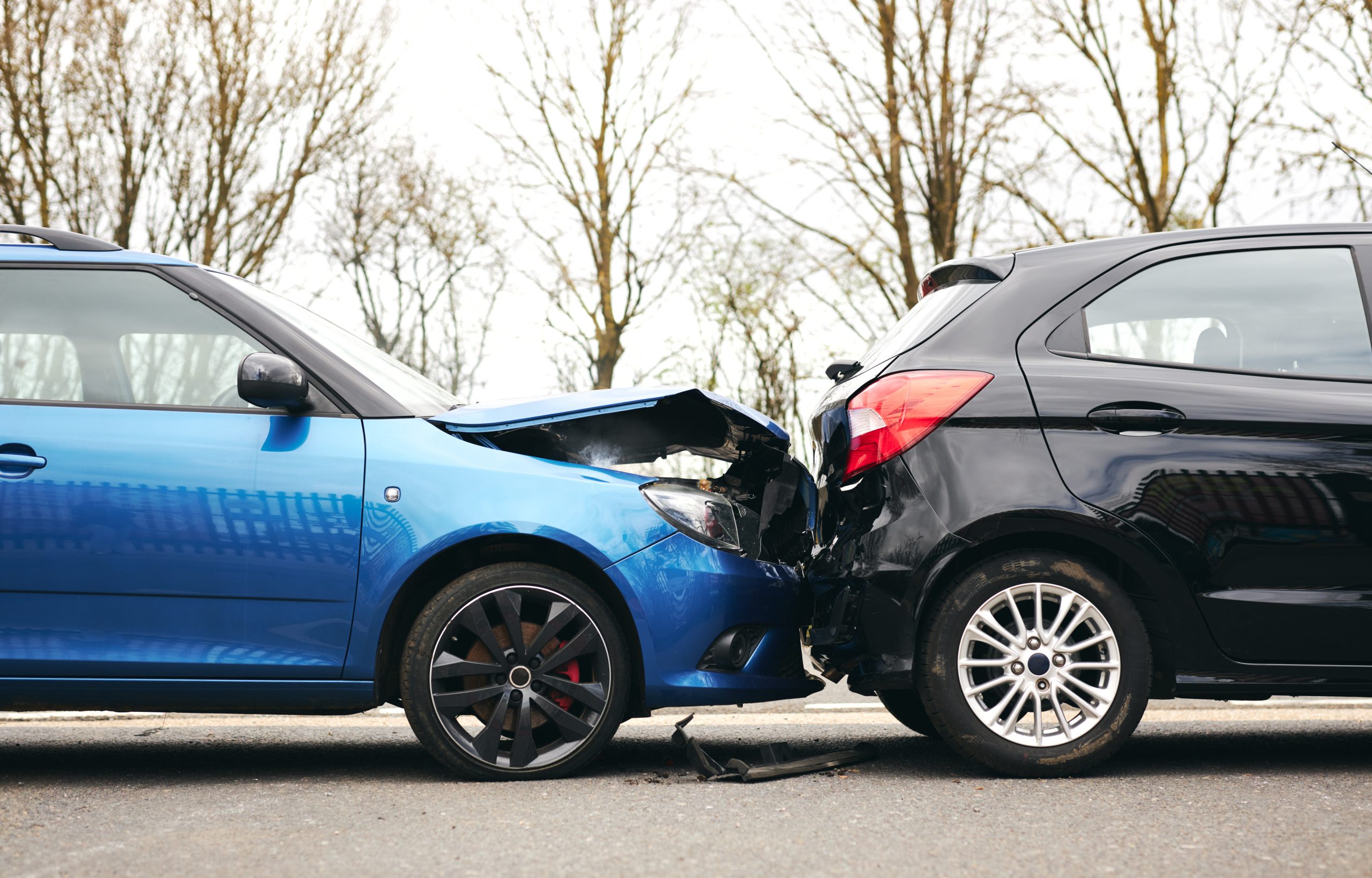 A blue and black car involved in a collision, with visible damage to the front and rear ends of both vehicles