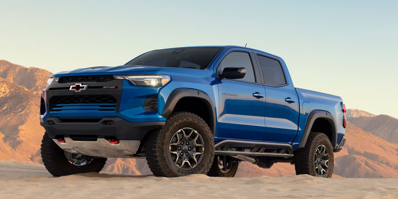 Blue Chevrolet Colorado truck in a desert landscape.