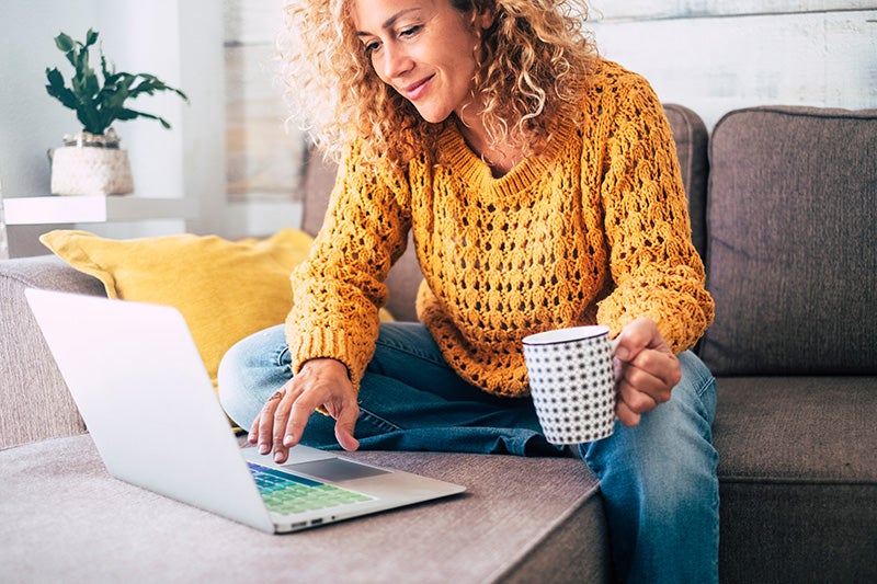 Woman using a laptop on a couch